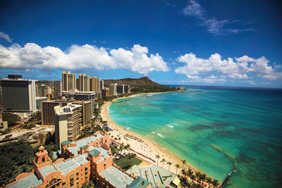 Many hotels and restaurants are positioned along the shoreline of bustling Waikiki Beach. Photo by Hawaii Tourism Authority (HTA)/Dana Edmunds.
