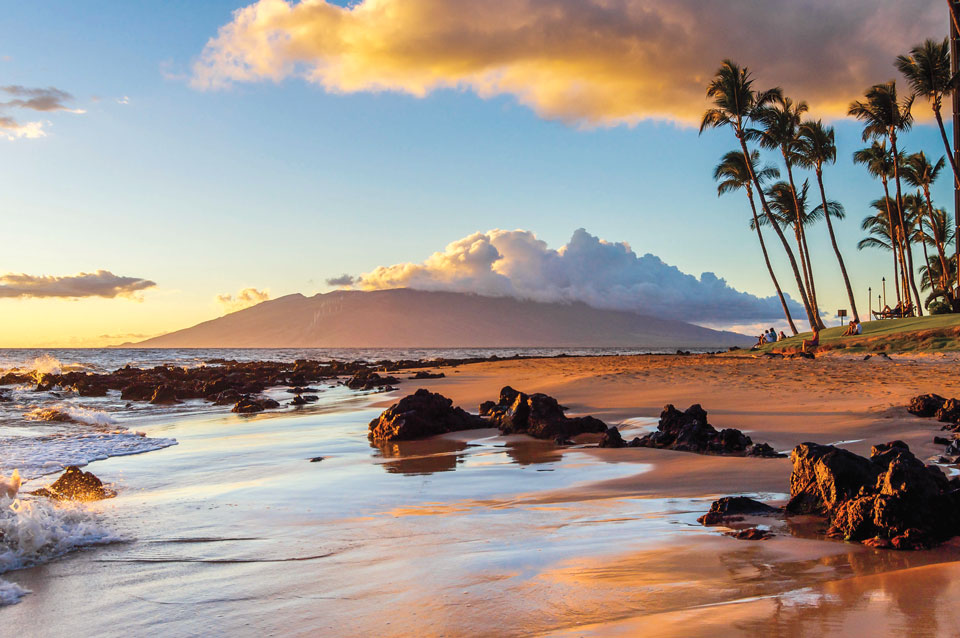 Enjoy a Hawaiian sunset on the beach in Maui. Shutterstock.