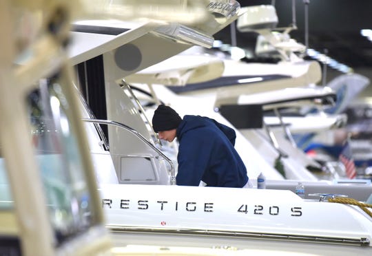 Colony Marine employee Austin Porter puts the finishing touches on a Prestige 420 S.