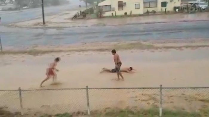 Children in Cunnamulla make the most of the downpour after receiving more than 30mm in some areas