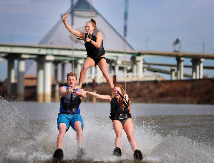 <strong>Ashley Piskorski waves to the dock from her perch on the shoulders of siblings Cole (left) and Kayla Piskorski during the 43rd annual Ski Freeze at the Mud Island River Park on Jan. 1, 2020. Hosted by the Collierville Ski Club, water skiers, barefooters and wakeboarders braved the frigid water of the Wolf River to raise money for The Dream Factory of Memphis which grants wishes for critically and chronically ill children ages 3 through 18.</strong> (Jim Weber/Daily Memphian)