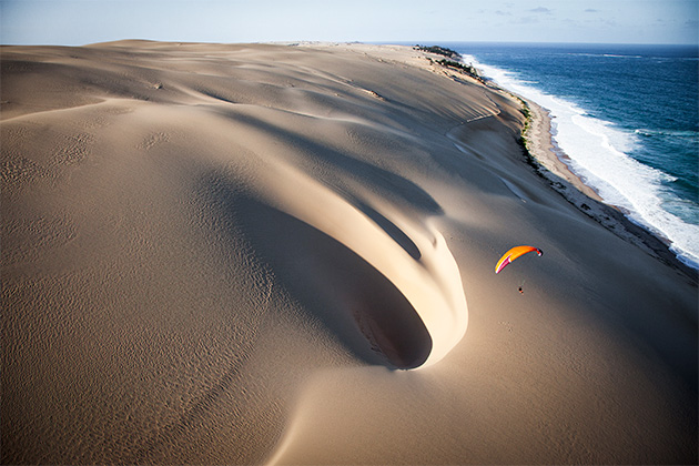 Jody Macdonald paraglider over dunes, Island of Bazaruto