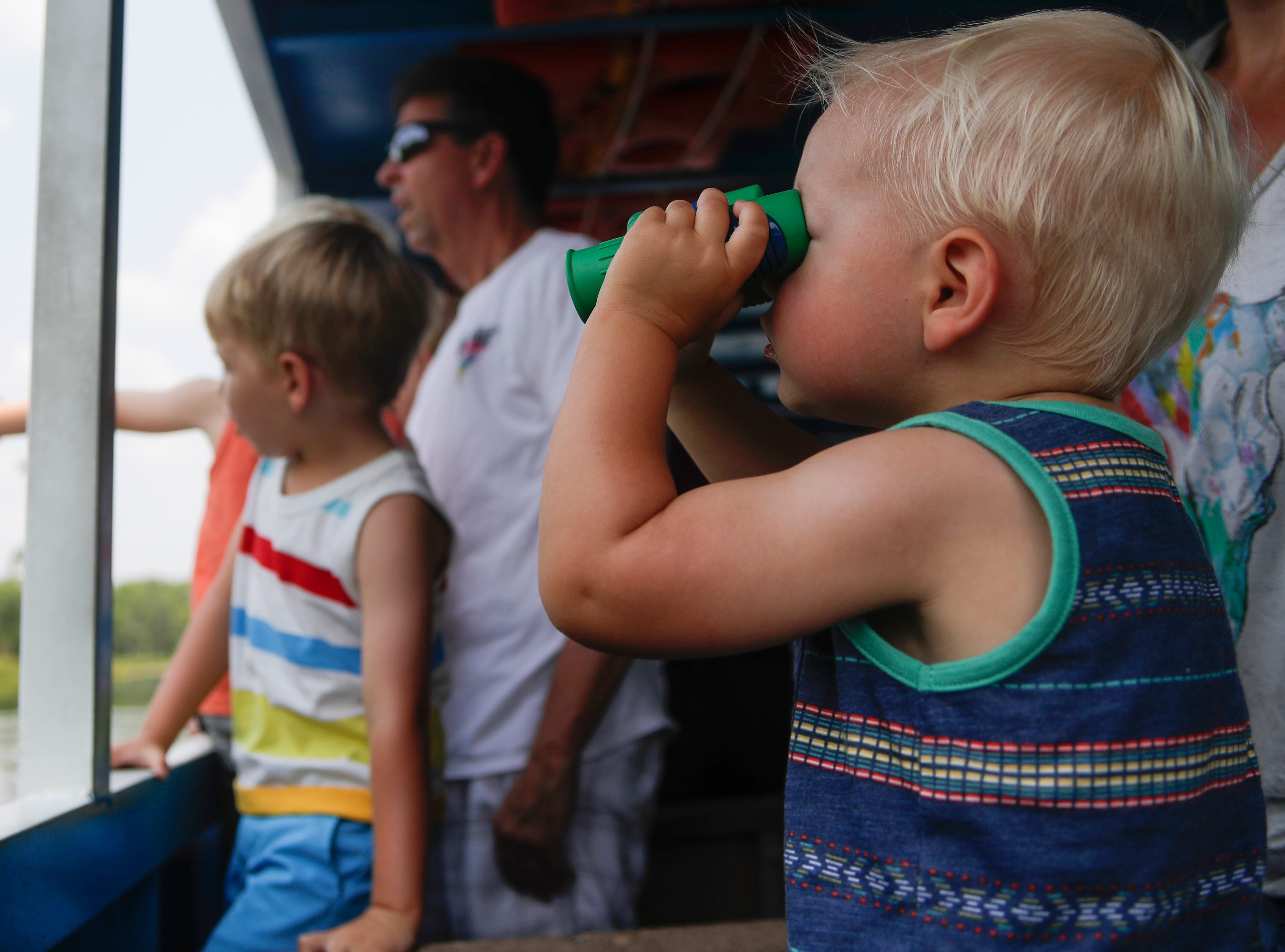 Cal Lounsbury, 1, looks for wildlife through his binoculars while on a historic boat tour at Wakulla Springs State Park Monday, June 3, 2019. 