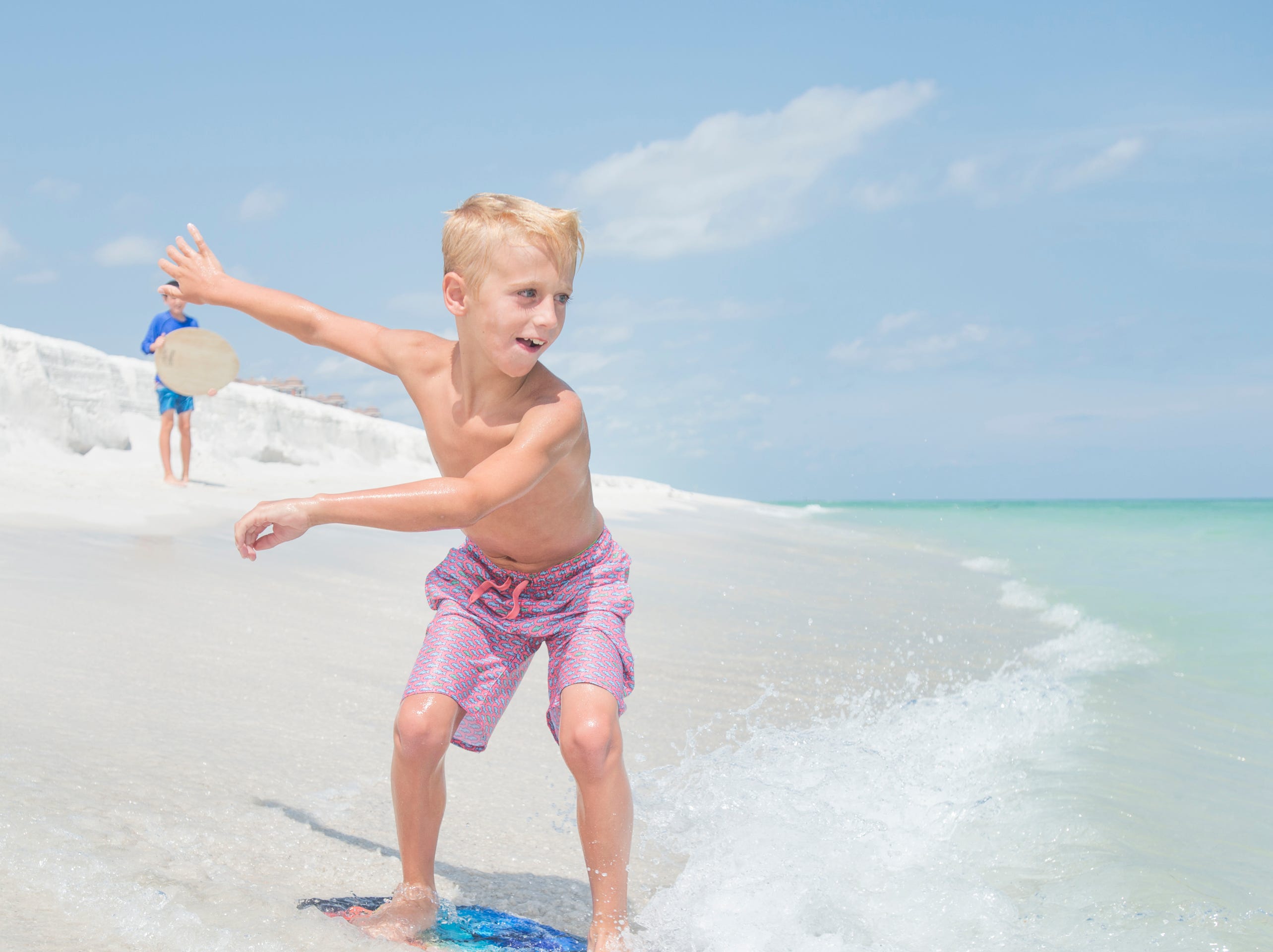 Knox Stephens, 8, of Magnolia, Arkansas, skimboards along Penacola Beach on Friday, July 20, 2018.