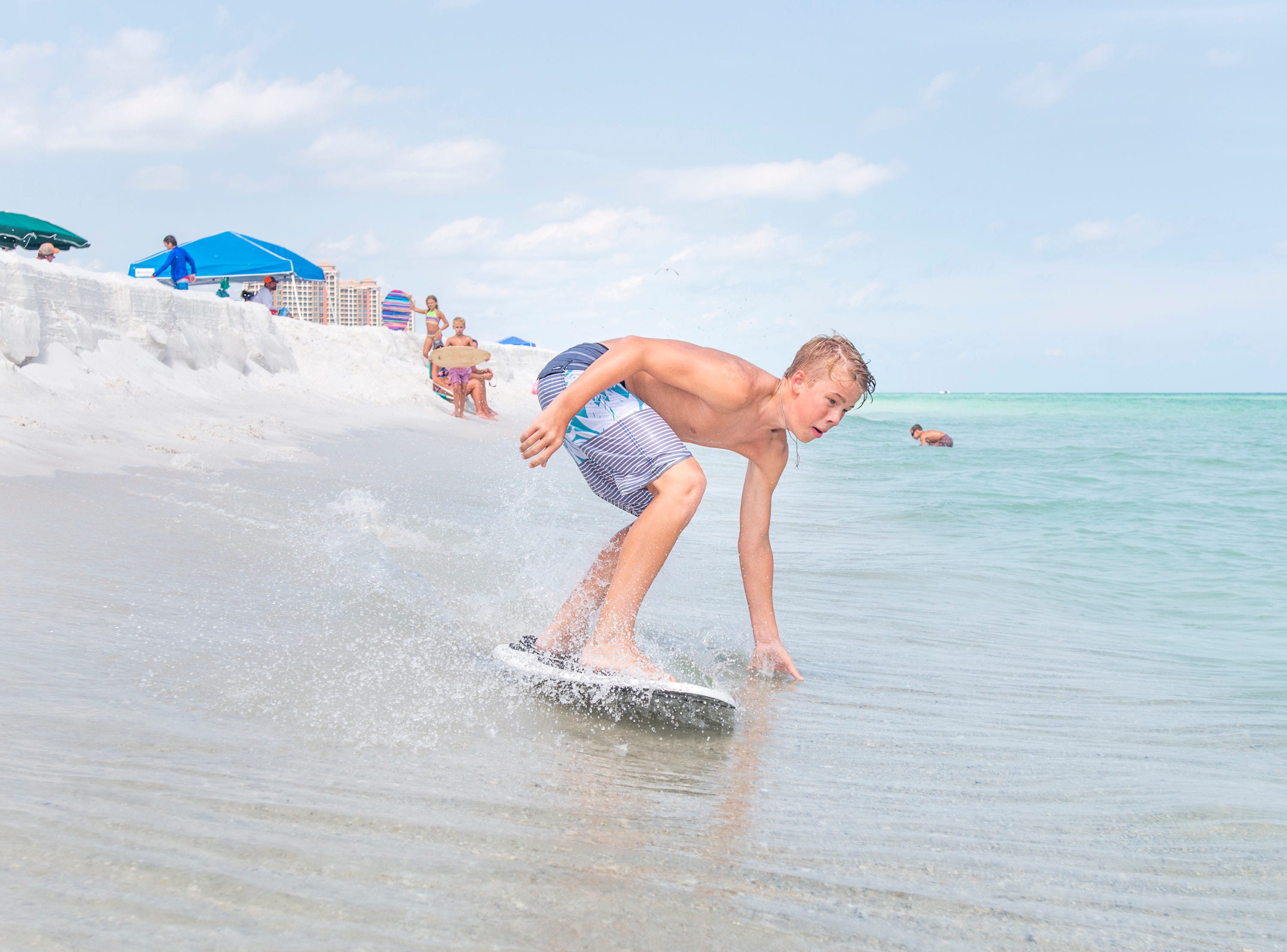 Wyatt West, 14, of New Braunfels, Texas skimboards along Penacola Beach on Friday, July 20, 2018.