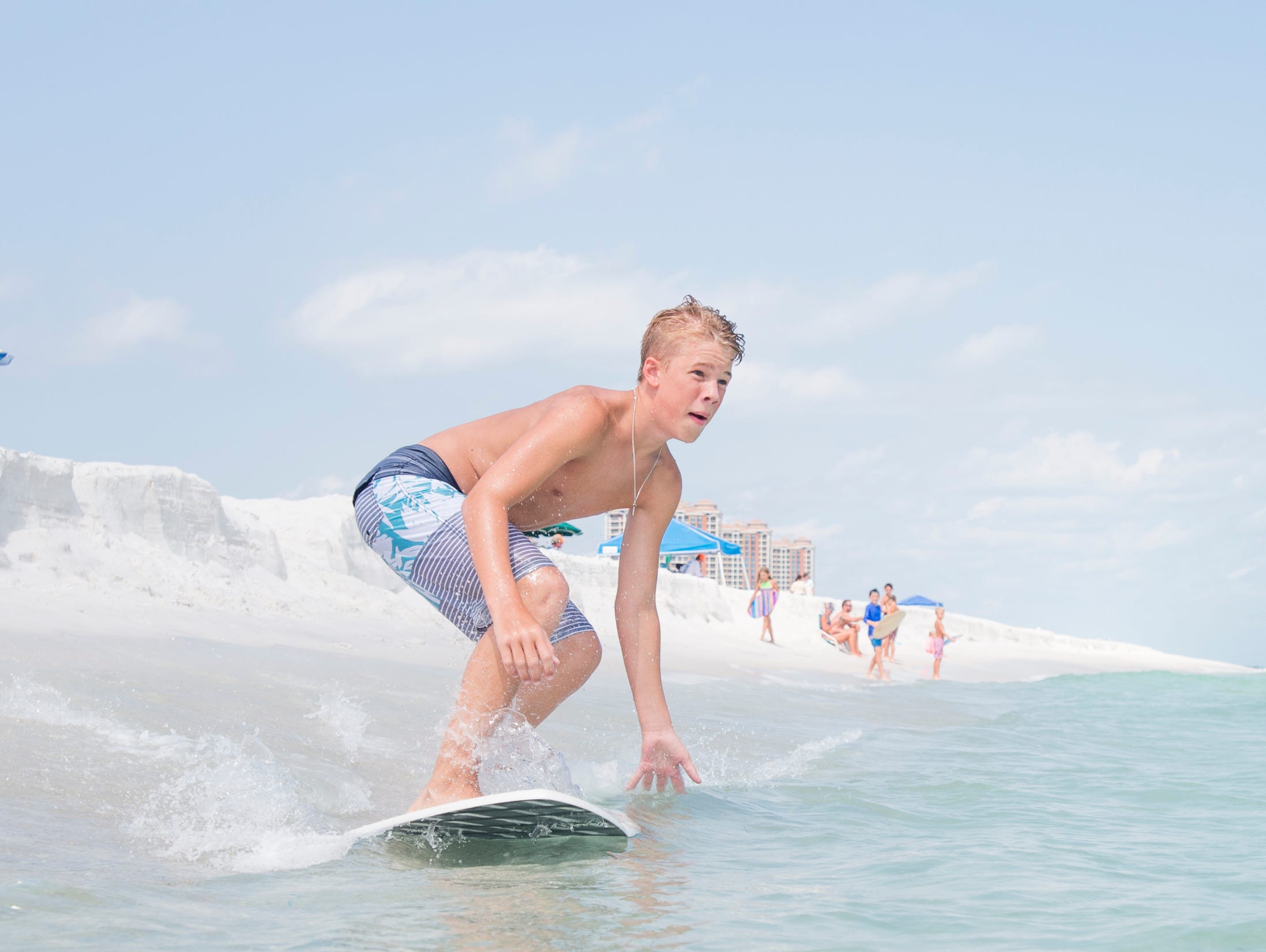 Wyatt West, 14, of New Braunfels, Texas skimboards along Penacola Beach on Friday, July 20, 2018.