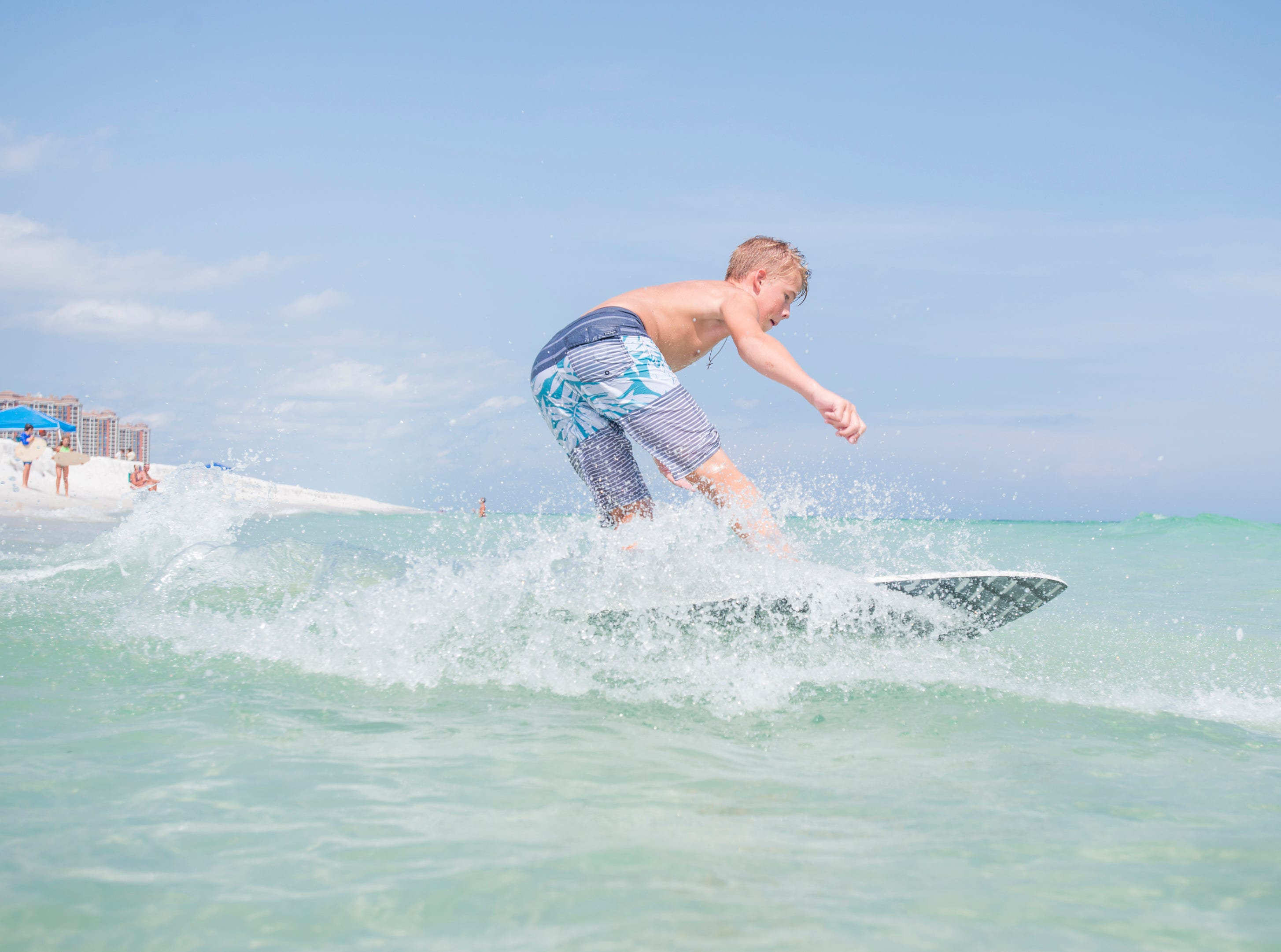 Wyatt West, 14, of New Braunfels, Texas skimboards along Penacola Beach on Friday, July 20, 2018.