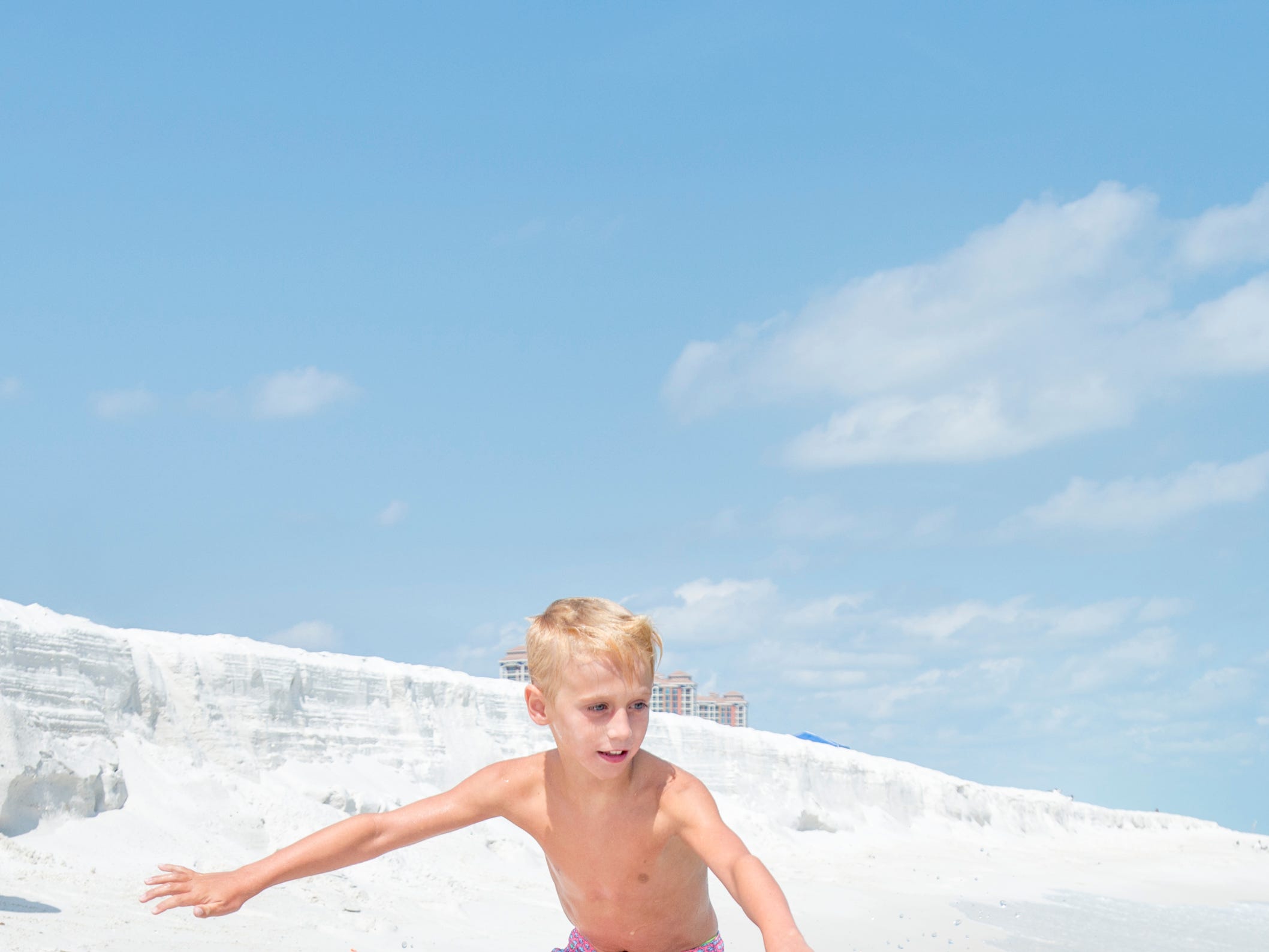 Knox Stephens, 8, of Magnolia, Arkansas, skimboards along Penacola Beach on Friday, July 20, 2018.