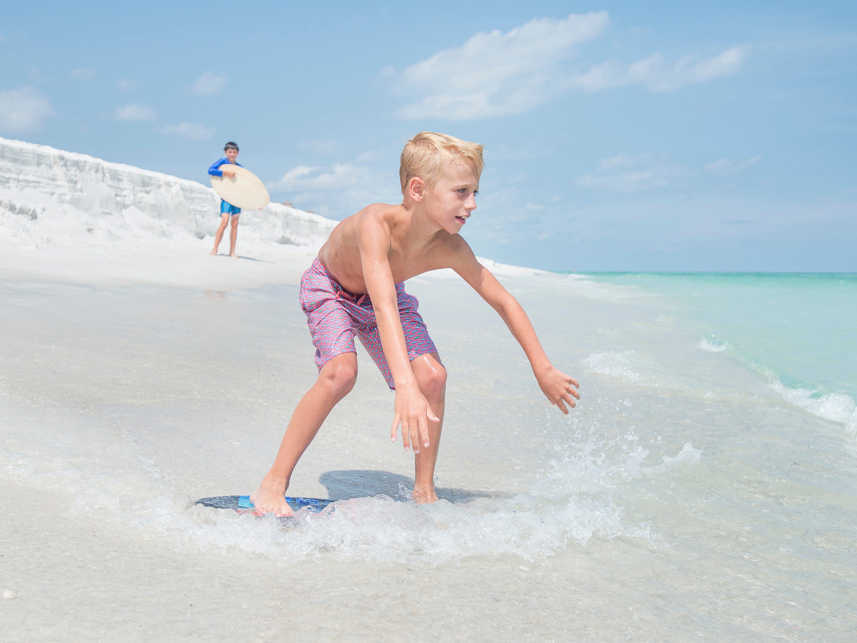 Knox Stephens, 8, of Magnolia, Arkansas, skimboards along Penacola Beach on Friday, July 20, 2018.