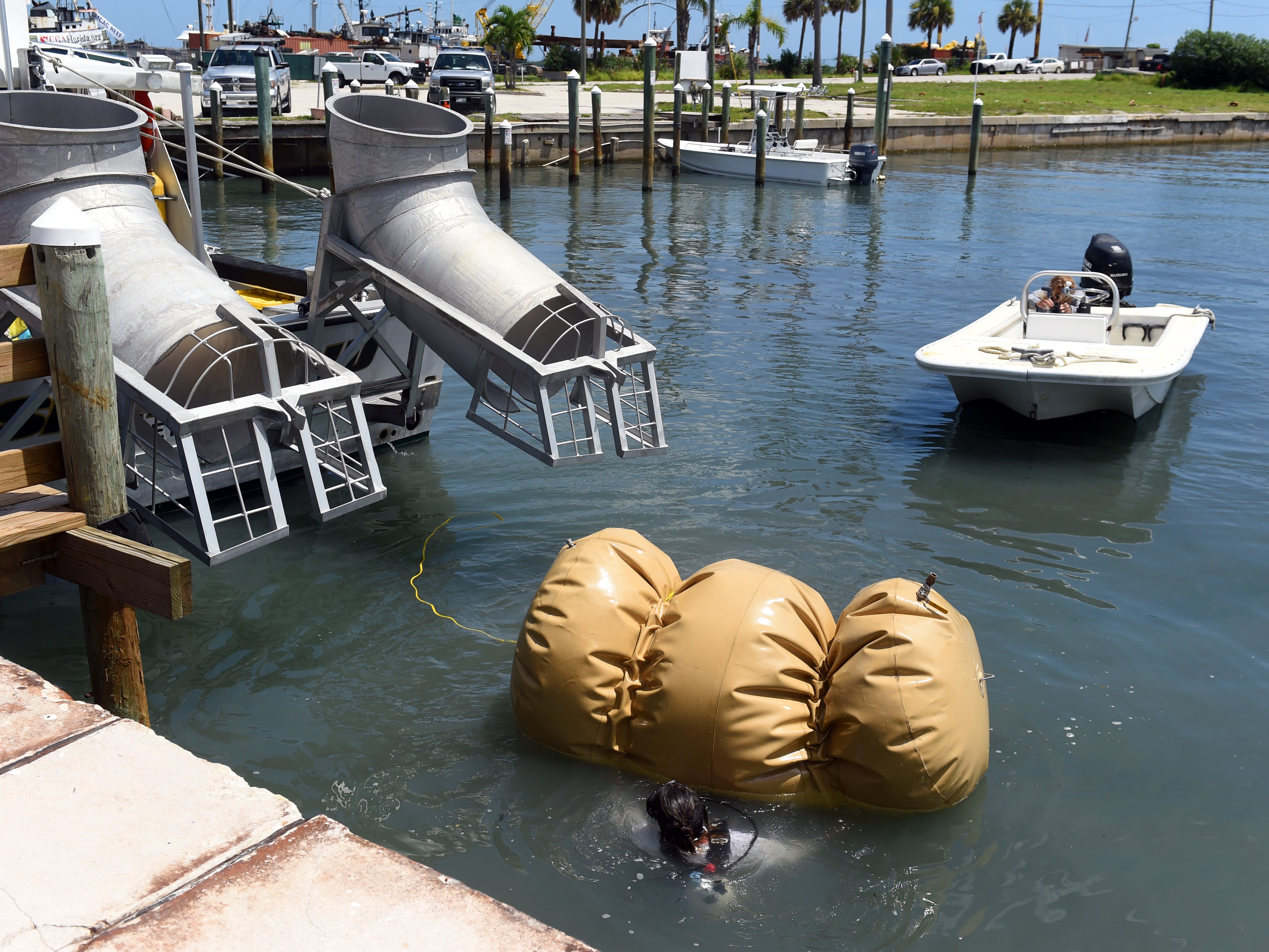 Levin Shavers, a member of the salvage crew with Maritime Research and Recovery, carefully removes the airbag used to float a cannon from the 1715 Spanish Plate Fleet before it is hoisted ashore on Monday, Aug. 13, 2018 at Fisherman's Wharf in Fort Pierce. The cannon, found off Sandy Point, will be treated and cleaned and put on display at Melody Lane Fishing Pier. The process will take about three years.