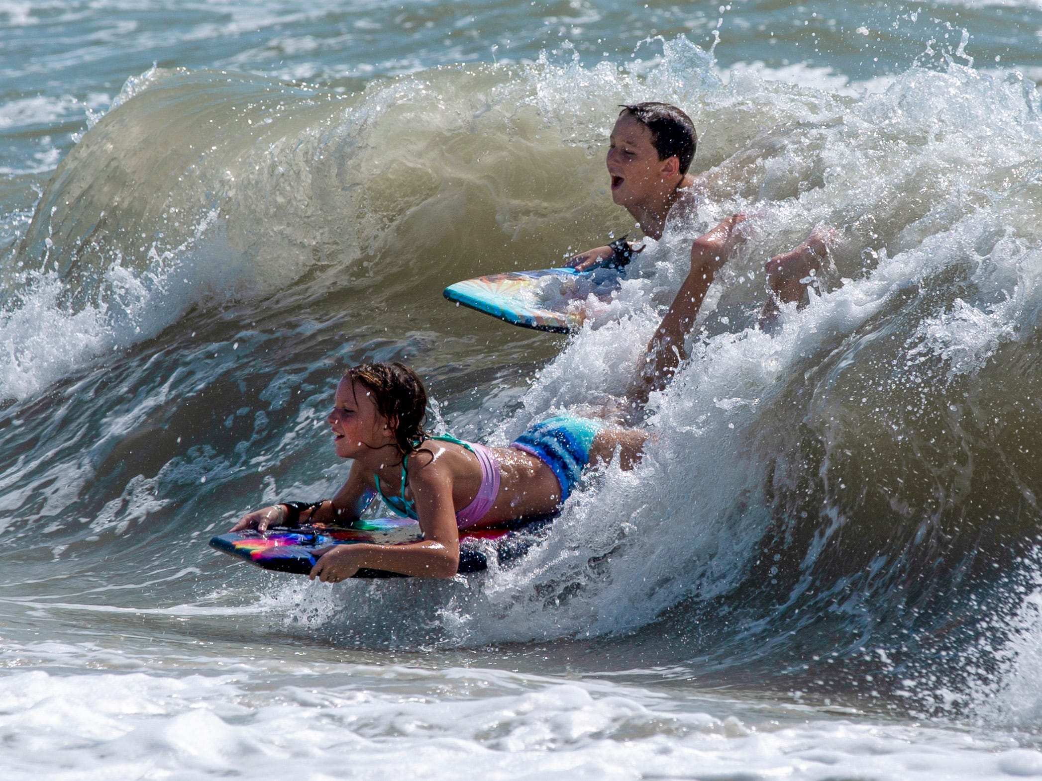 Two teenagers catch a wave near the Naples Beach on Tuesday, September 3, 2019. Locals and tourists continue visiting scenic spots in Naples, taking advantage of heavy winds and waves bought on by Hurricane Dorian.
