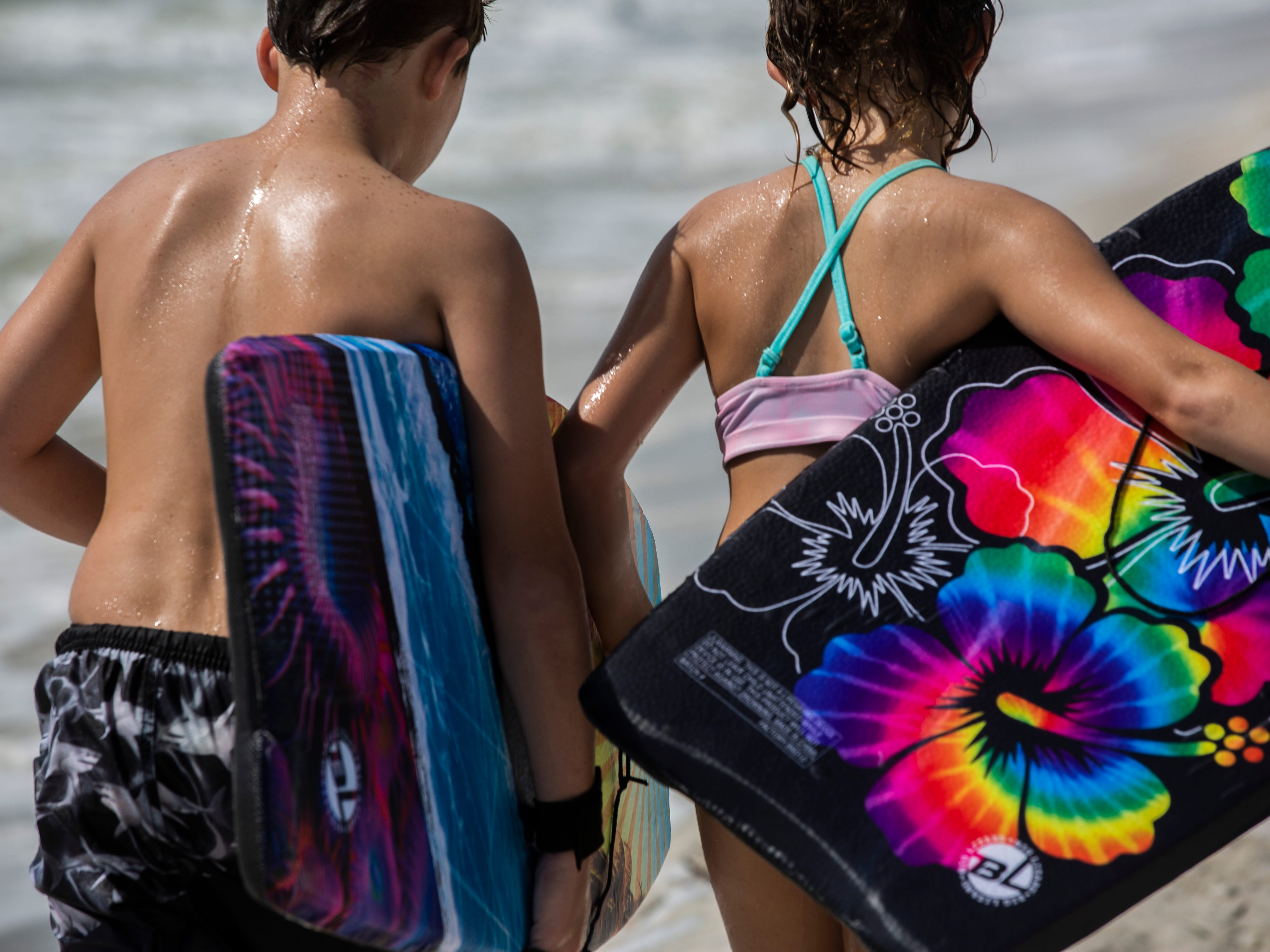 Teenagers walk along the shore of Naples Beach on Tuesday, September 3, 2019. Locals and tourists continue visiting scenic spots in Naples, taking advantage of heavy winds and waves bought on by Hurricane Dorian.