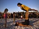 Megan Meredith and Victor Rios practice acro yoga together in the center of the community drum circle at Siesta Key Beach on Sunday, January 21, 2018 in Sarasota. Spectators dance and perform in the center. 