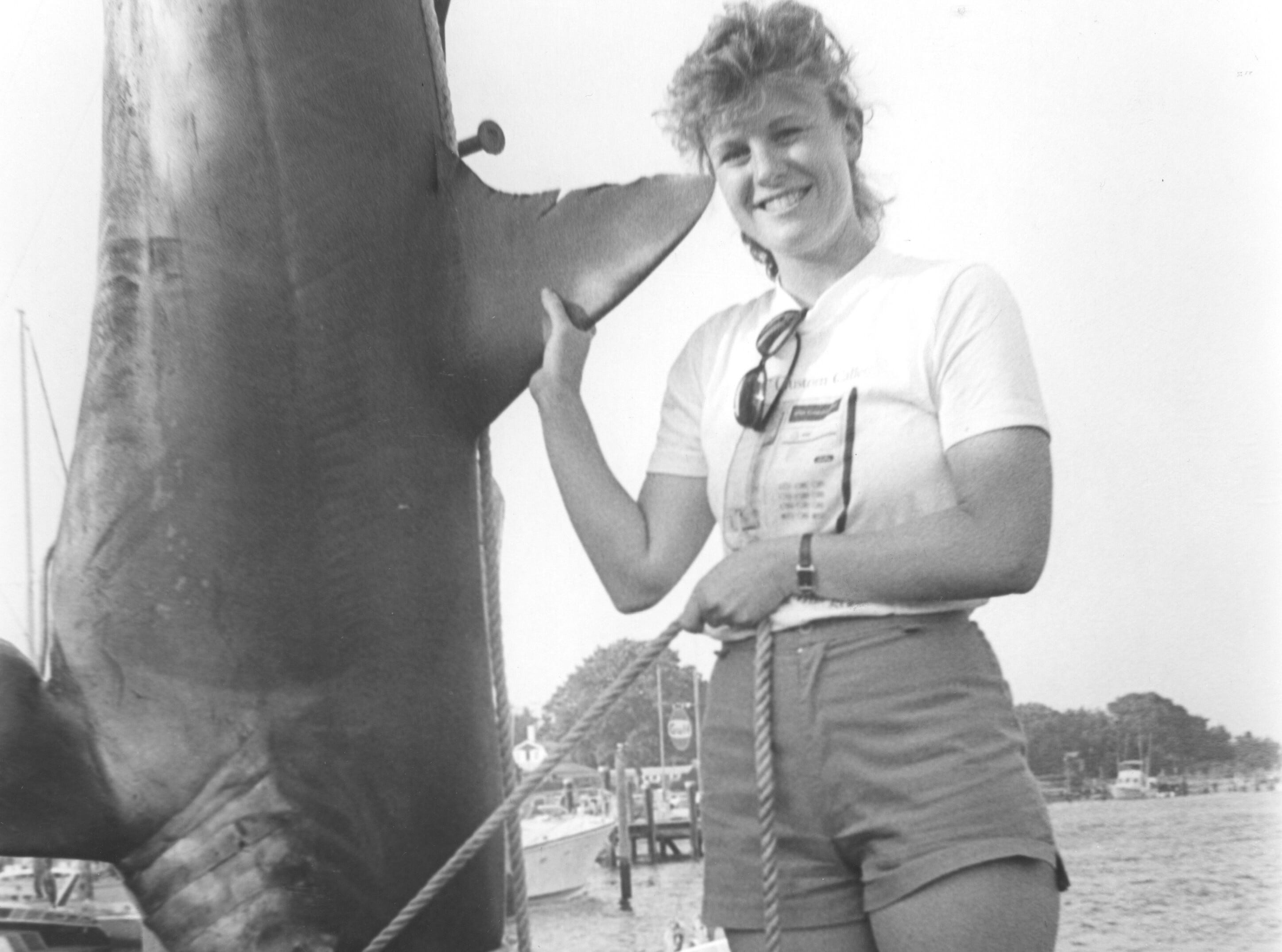 (AUG. 8, 1987) Michelle Walsh of North Brunswick Township shows a 442-pound mako shark, which was caught by fishermen aboard the Suzie Q, out of Point Beach, some 16 miles off Manasquan Inlet.