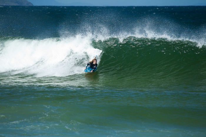 Millie Chalker riding barrel of a wave.