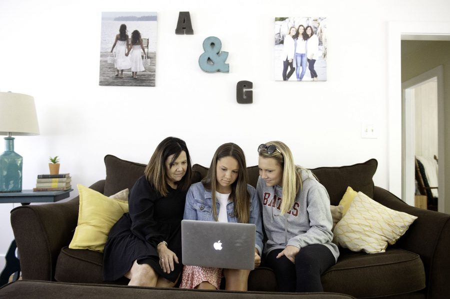 Bates College graduate Anna Beaudet, center, watches the 2020 Bates Commencement ceremony on her laptop with her mother, Celeste, left, and sister, Bates College sophomore Grace, at their home in Auburn on Sunday. Graduation ceremonies were pre-recorded because of the COVID-19 pandemic.