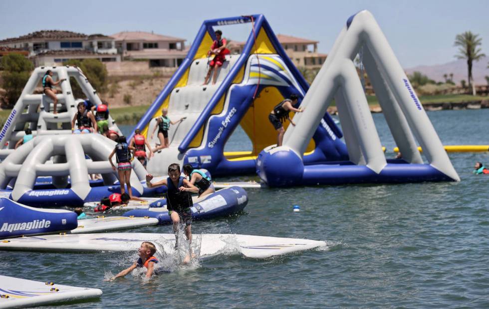People play at the recently opened Aqua Park at Lake Las Vegas in Henderson Thursday, June 11, ...
