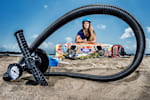 Ines Correia on the beach with her surfboard, photographed through a tube 