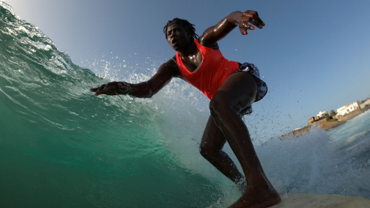 Sambe surfs during a training session off the coast of Ngor, Dakar, Senegal, August 18. "I always think to myself, when I wake up in the morning, 'Khadjou, you've got something to do, you represent something everywhere in the world, you must go straight to the point, don't give up, whatever people say, whatever they say don't listen, go forward so that everybody can get up and believe they can surf." (Image: Reuters)