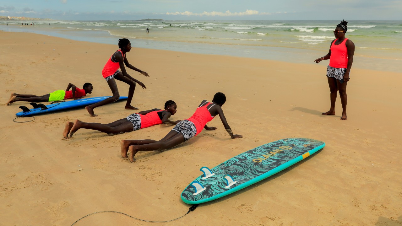 Sambe trains beginners with Black Girls Surf (BGS), a training school for girls and women who want to compete in professional surfing, on the sand at Yoff beach, in Dakar. (Image: Reuters)