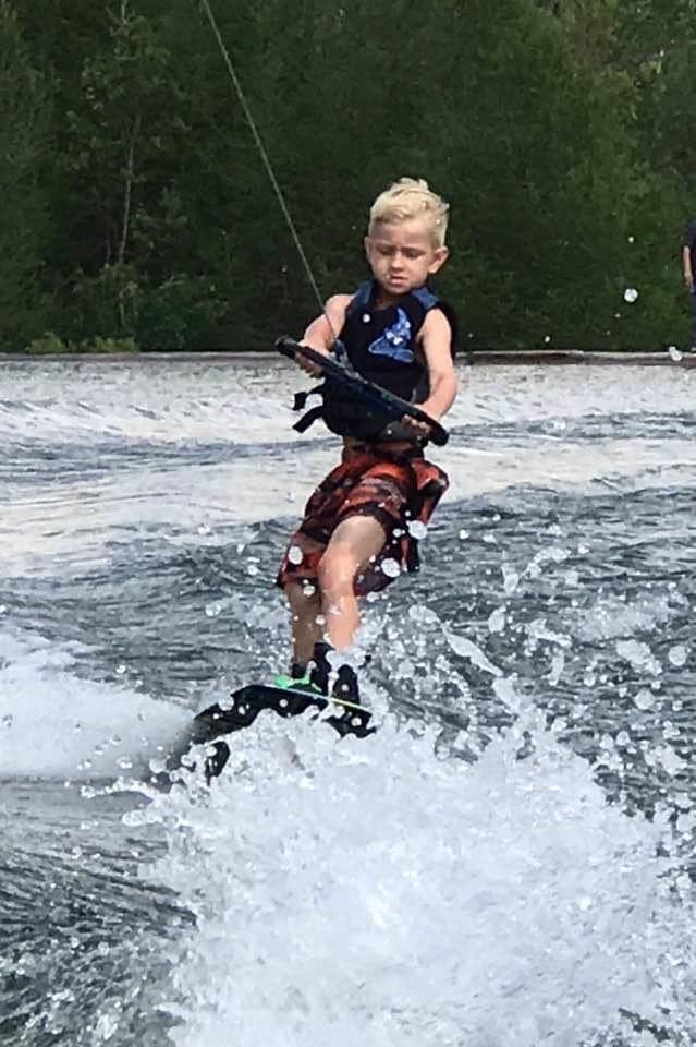 Photo shows Andrew Brady water skiing on a lake. 
