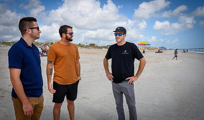 Jon Simone talks with Al Angyalfy and Pat Conner on St. Augustine Beach on Wednesday near where the two men rescued him from the water in August.