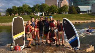 A groups of Dayton, Ohio surfers pose next to surfboards