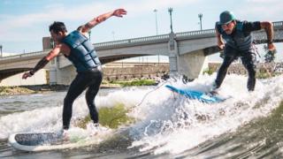 Surf Dayton cofounder Jake Brown and Shannon Thomas riding river waves