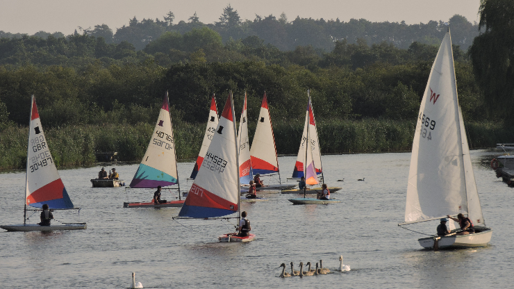 Toppers and a Wayfarer sailing on a river