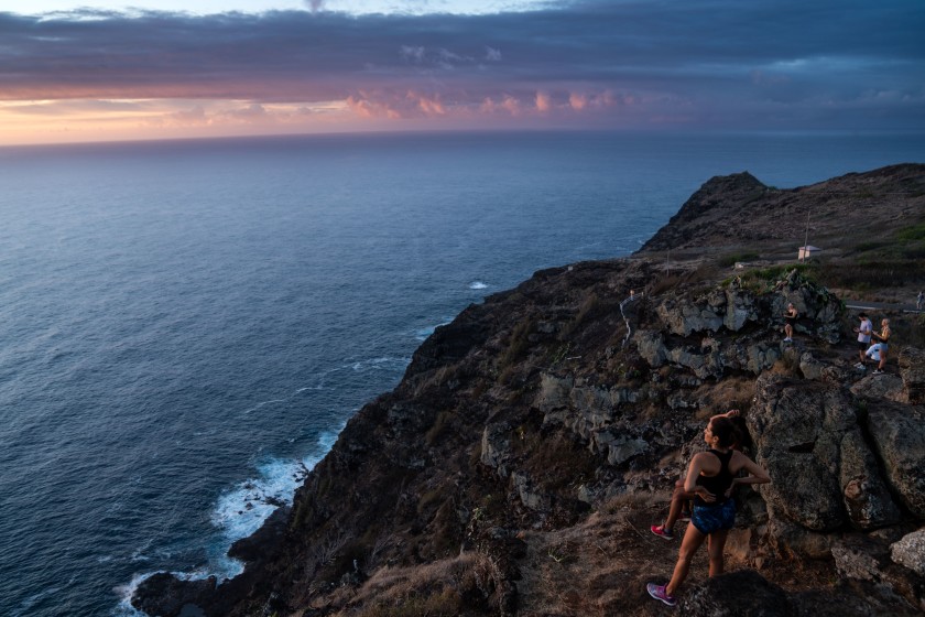 Hikers watch the sunrise on Oahu.